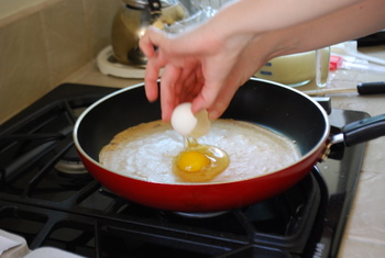 Breaking an egg onto the crepe