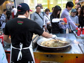 Street food vendor frying up fish cakes